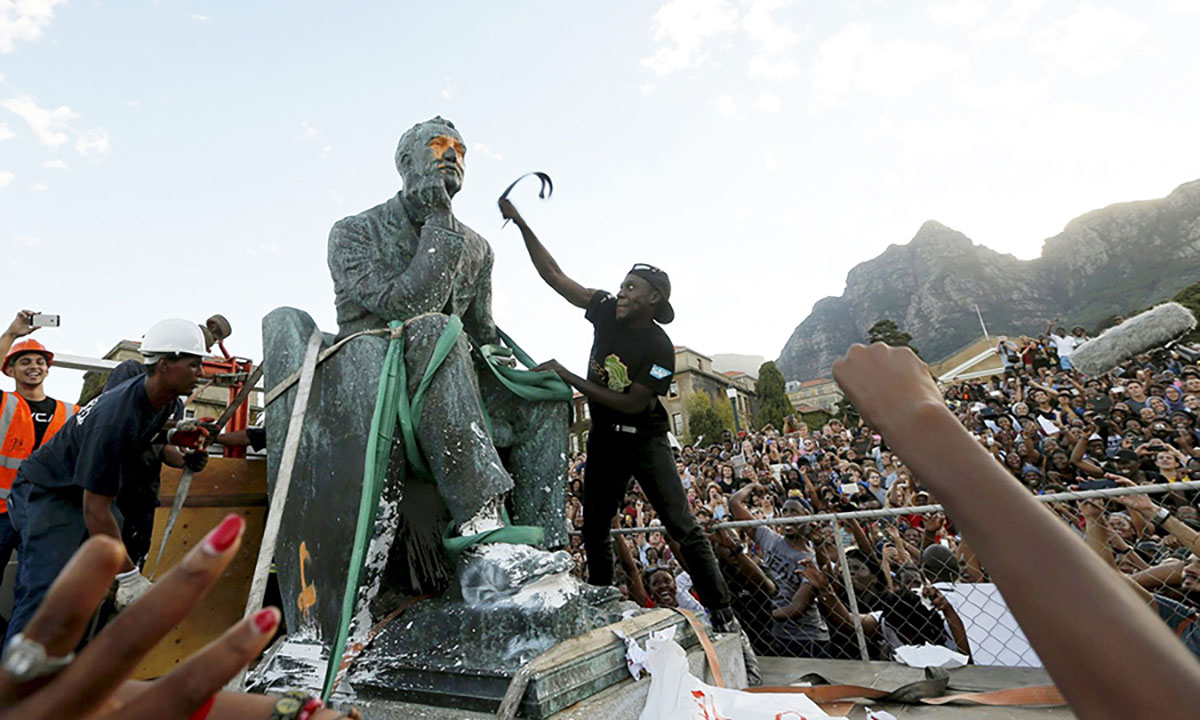 Students attacking Cecil Rhodes’s statue in Cap, South Africa – the statue will be finally removed – April 2015. Image: Mike Hutchings.